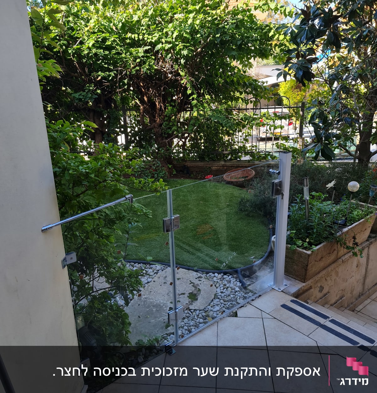 גדר זכוכית עם מחברים מתכתיים בגינה ירוקה